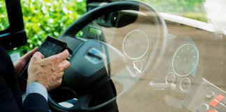 Kierowca autobusu rozmawia przez słuchawki